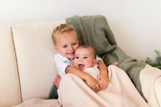 big brother with his baby sister on the couch