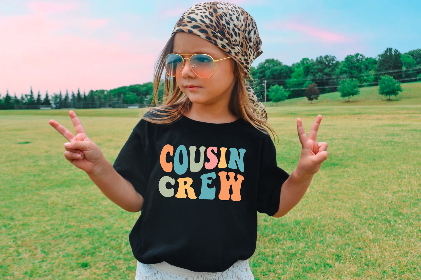 Girl wearing a black shirt with a cousin crew design printed on the shirt