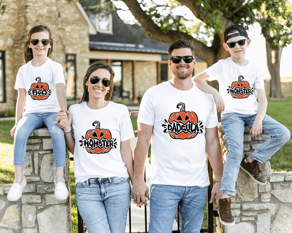 A happy family wearing matching pumpkin Halloween shirts