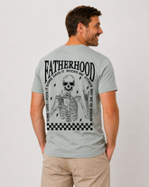 Man wearing a light gray t-shirt with a skeleton design and text on the back, on a plain background.