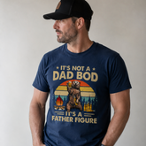 Man wearing a navy blue t-shirt with a graphic and text, standing against a plain background