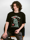 Person wearing a black t-shirt with a Christmas graphic design that says " I'm not thinking, I'm regretting secret santa"