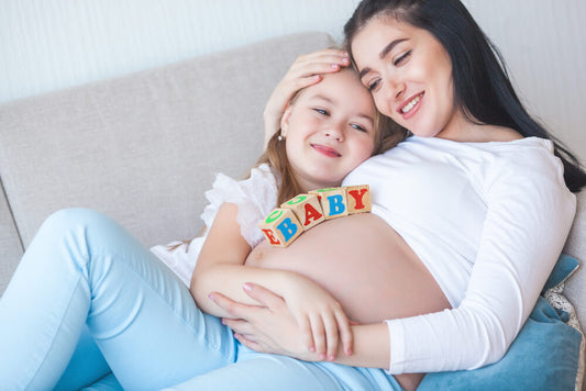 Mom and daughter posing for a pregnancy announcement photoshoot