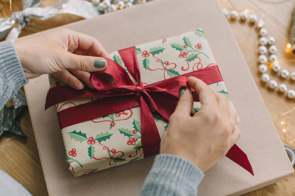 tying a ribbon on a Christmas gift