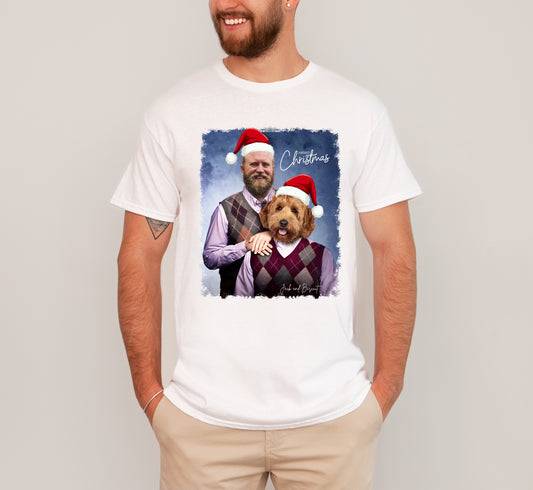 Person wearing a white t-shirt with a graphic of a man and dog wearing Santa hats and the word 'Christmas'.
