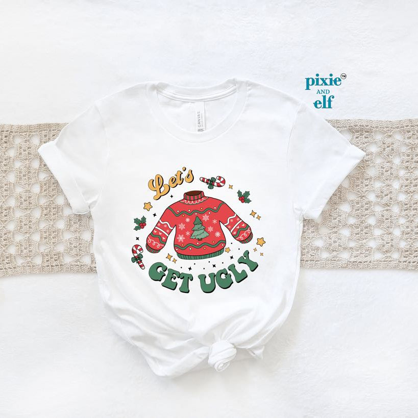 A white Christmas themed t-shirt with text and decorations, placed on a white surface with a red ugly sweater and the text " Let's get Ugly"