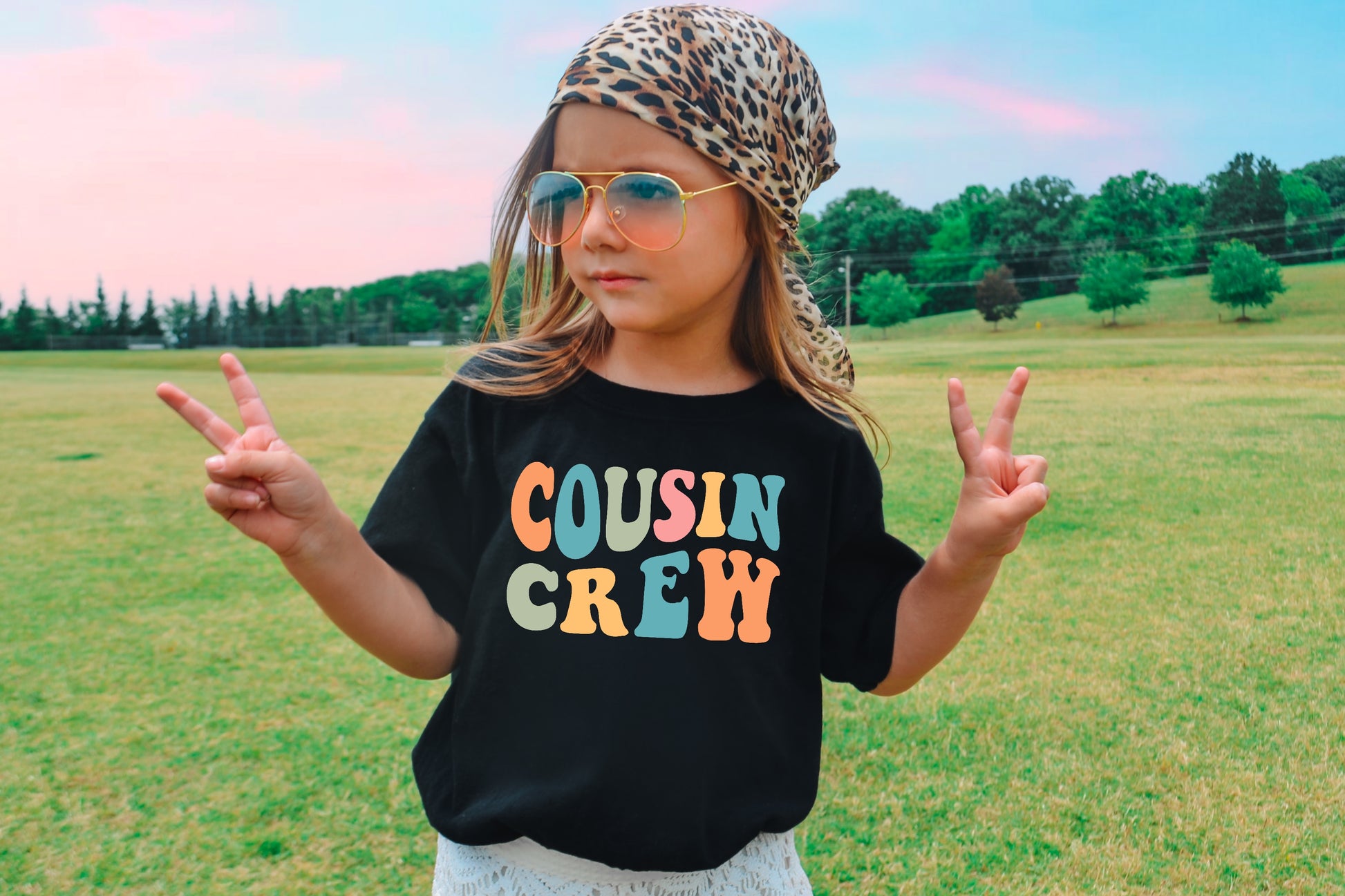 Girl wearing a black shirt with a cousin crew design printed on the shirt