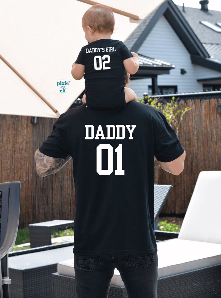Back view of Daddy and Daddy's Girl matching black varsity shirts with custom numbers