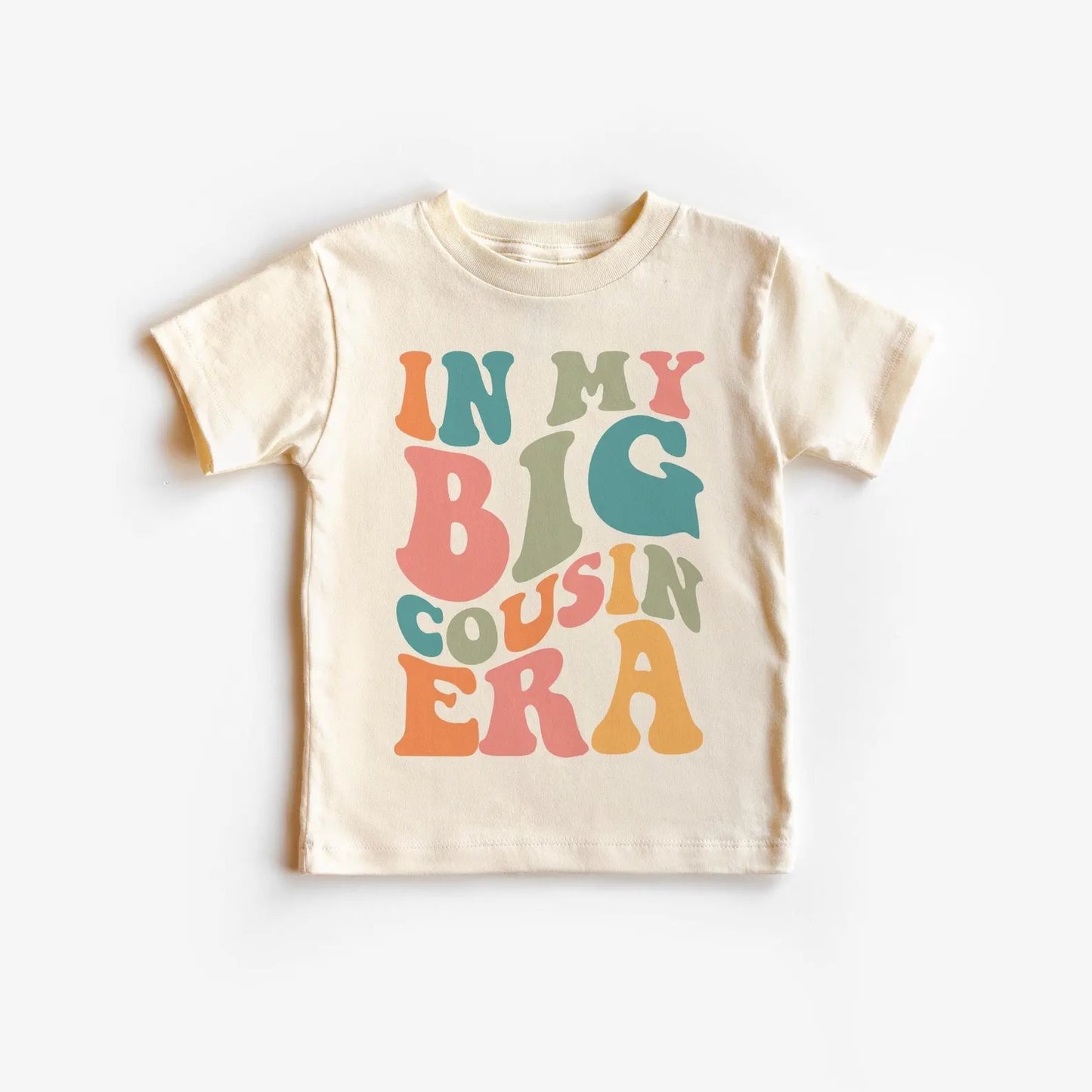 Beige t-shirt with colorful text 'IN MY BIG COUSIN ERA' on a white background