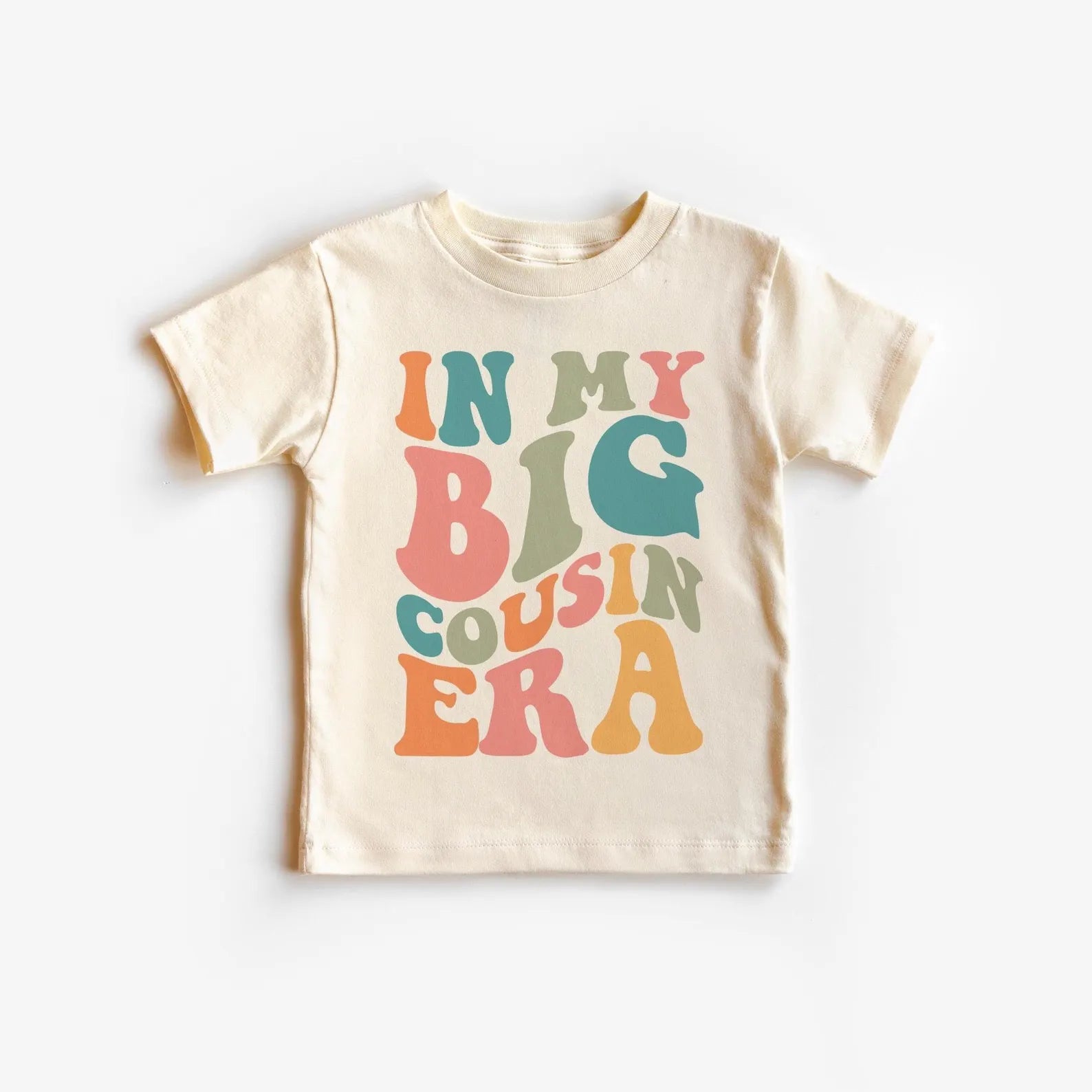 Beige t-shirt with colorful text 'IN MY BIG COUSIN ERA' on a white background