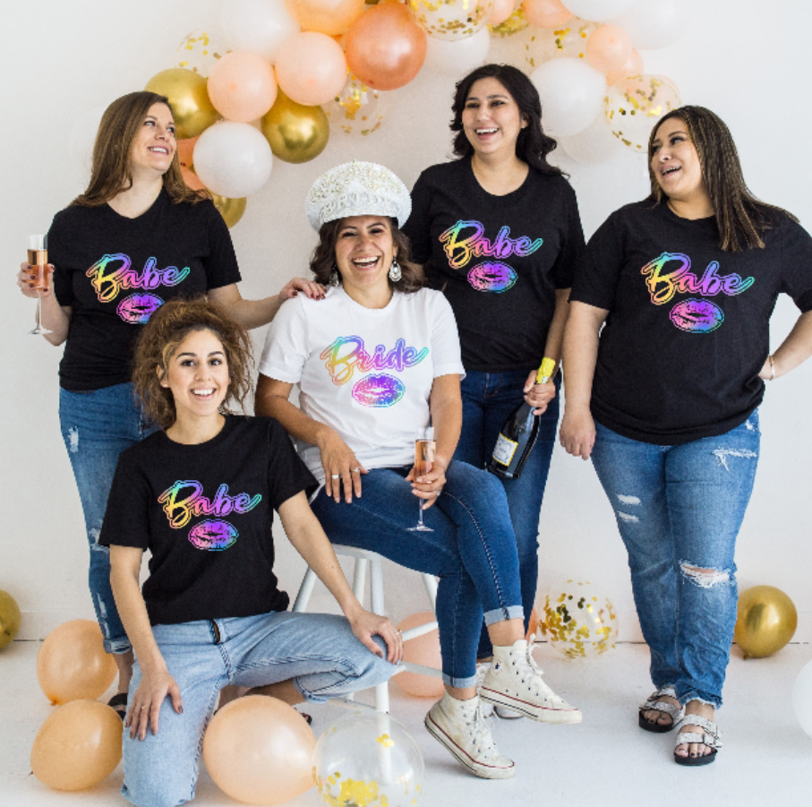 Group of women wearing 'Babe' t-shirts with colorful text, celebrating a bachelorette party.