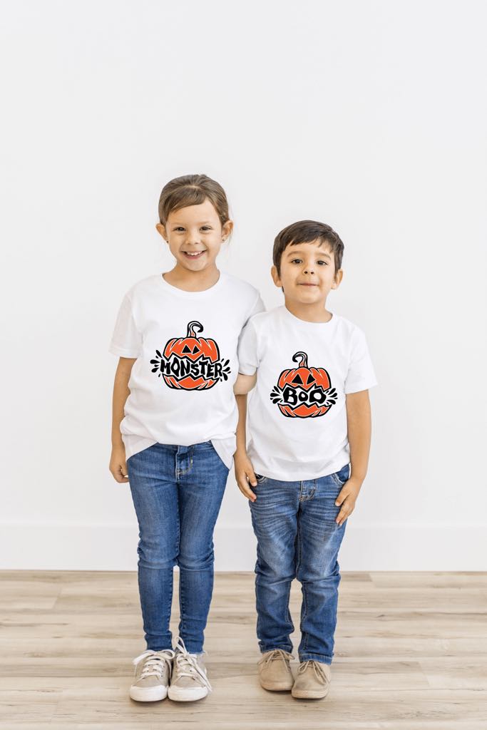 Brother and sister wearing matching pumpkin Halloween shirts