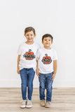 Brother and sister wearing matching pumpkin Halloween shirts