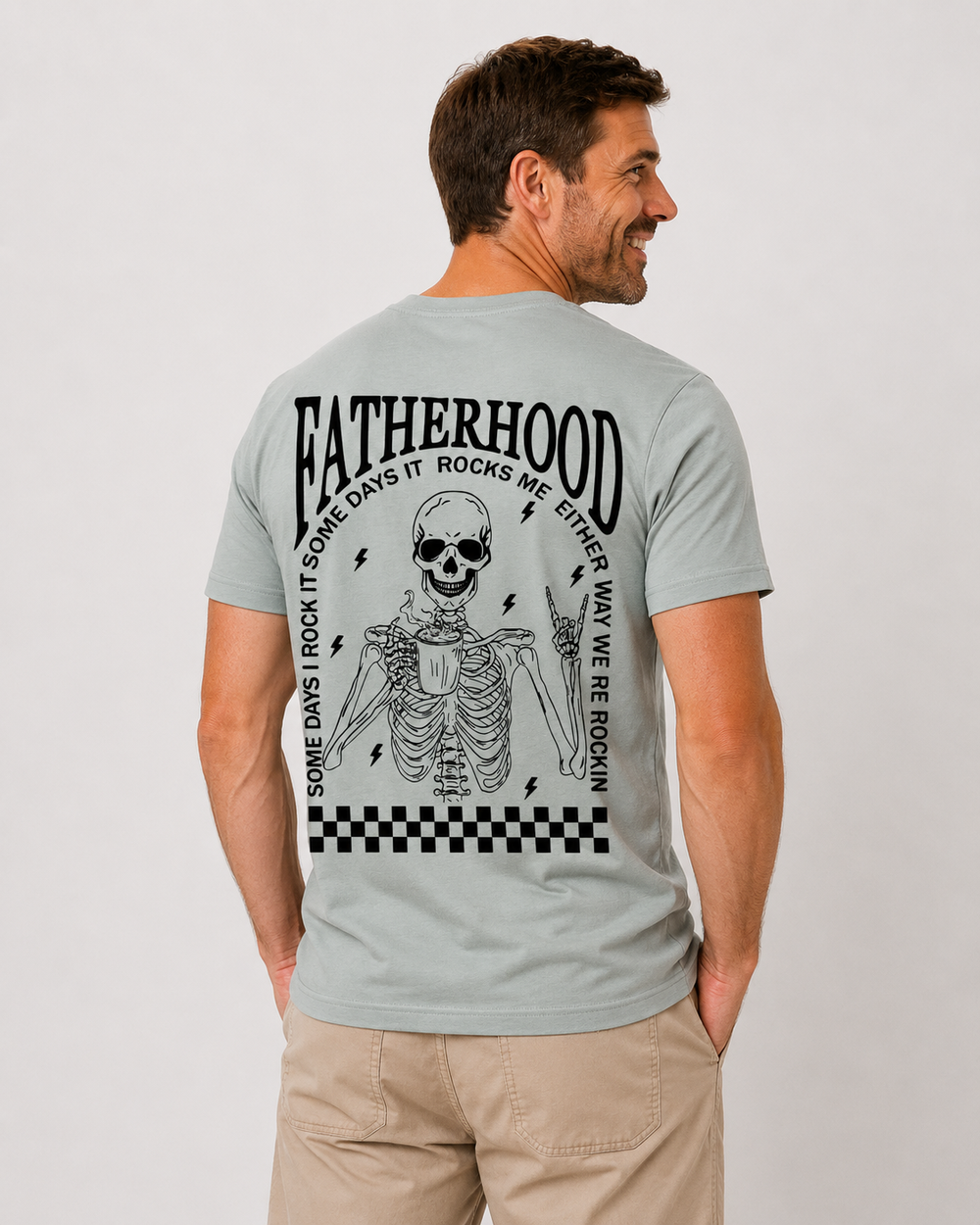 Man wearing a light gray t-shirt with a skeleton design and text on the back, on a plain background.