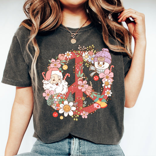 Person wearing a dark gray t-shirt with a colorful peace sign design featuring Santa Claus and winter elements.