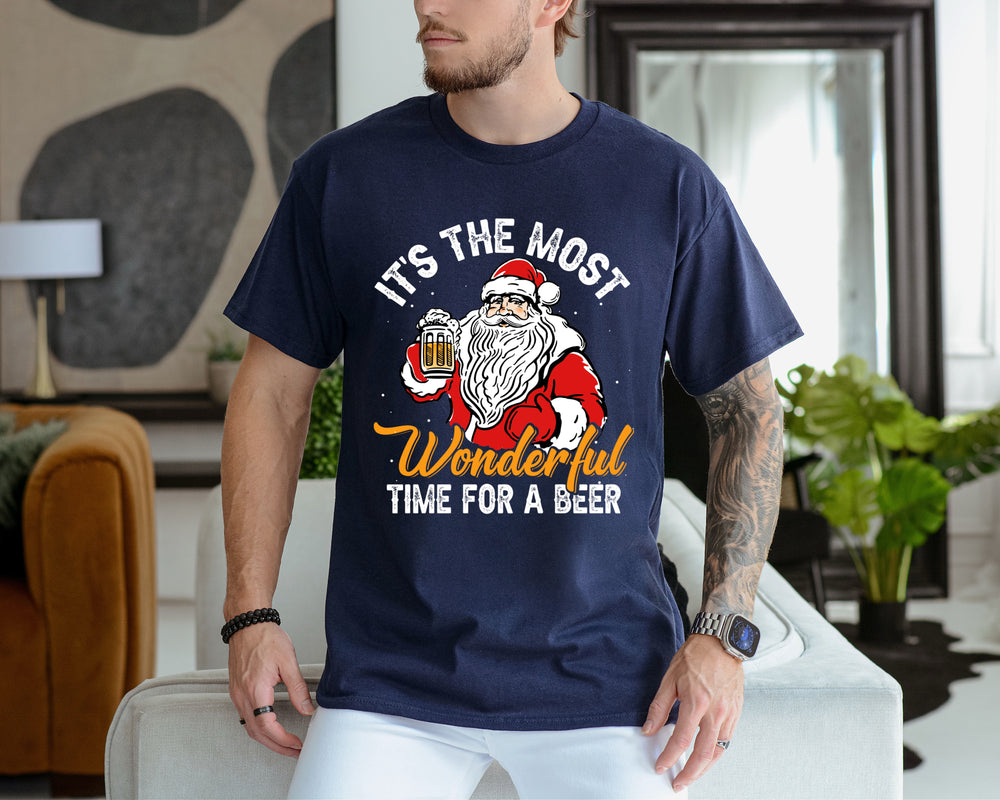 Man wearing a navy blue t-shirt with a Santa Claus graphic and text in a living room.