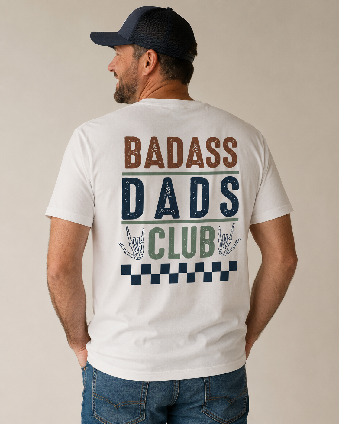 Man wearing a white t-shirt with 'BADASS DADS CLUB' text on the back against a beige background