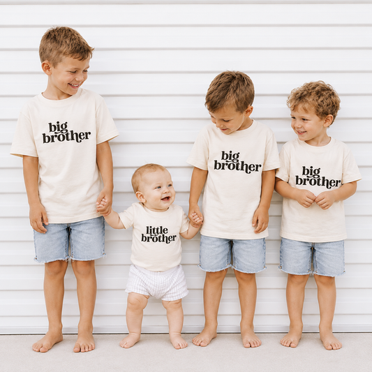 Four children wearing 'big brother' and 'little brother' shirts against a white background.