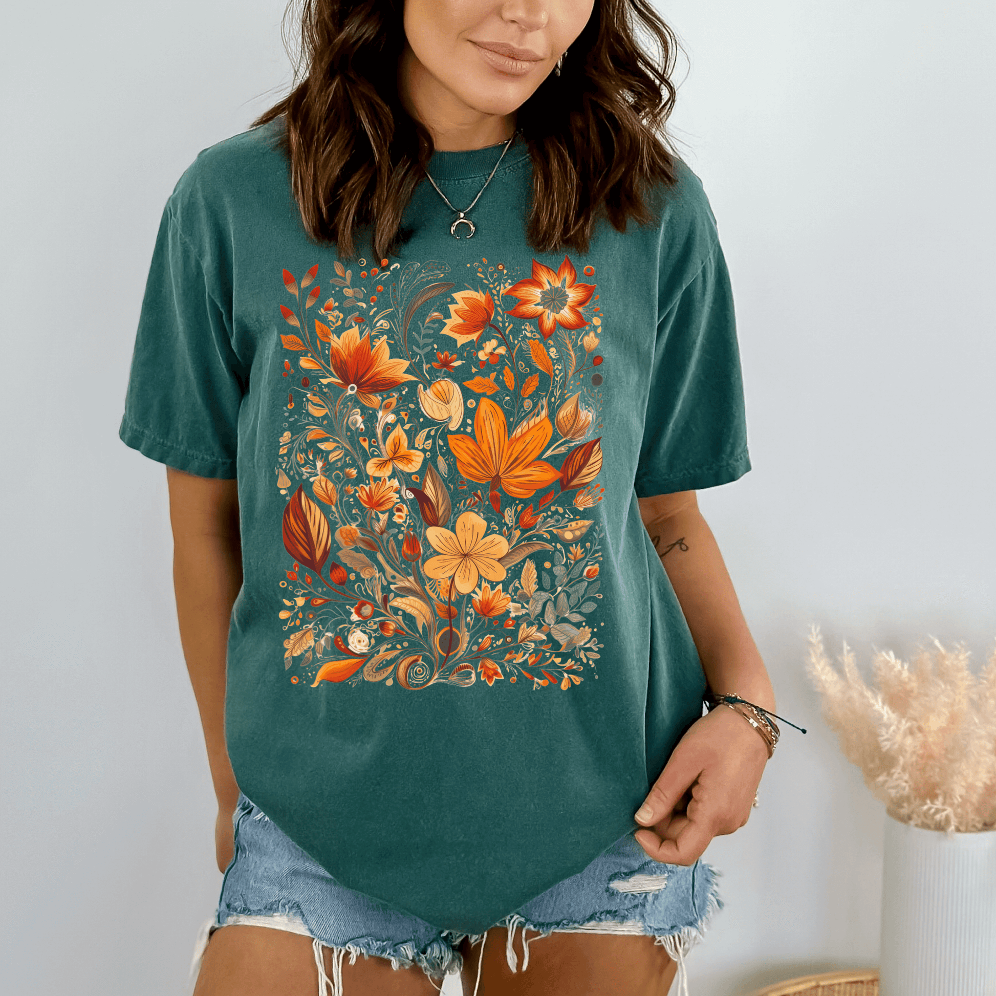 A person wearing a green t-shirt with a floral wildflower graphic design.