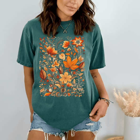 A person wearing a green t-shirt with a floral wildflower graphic design.