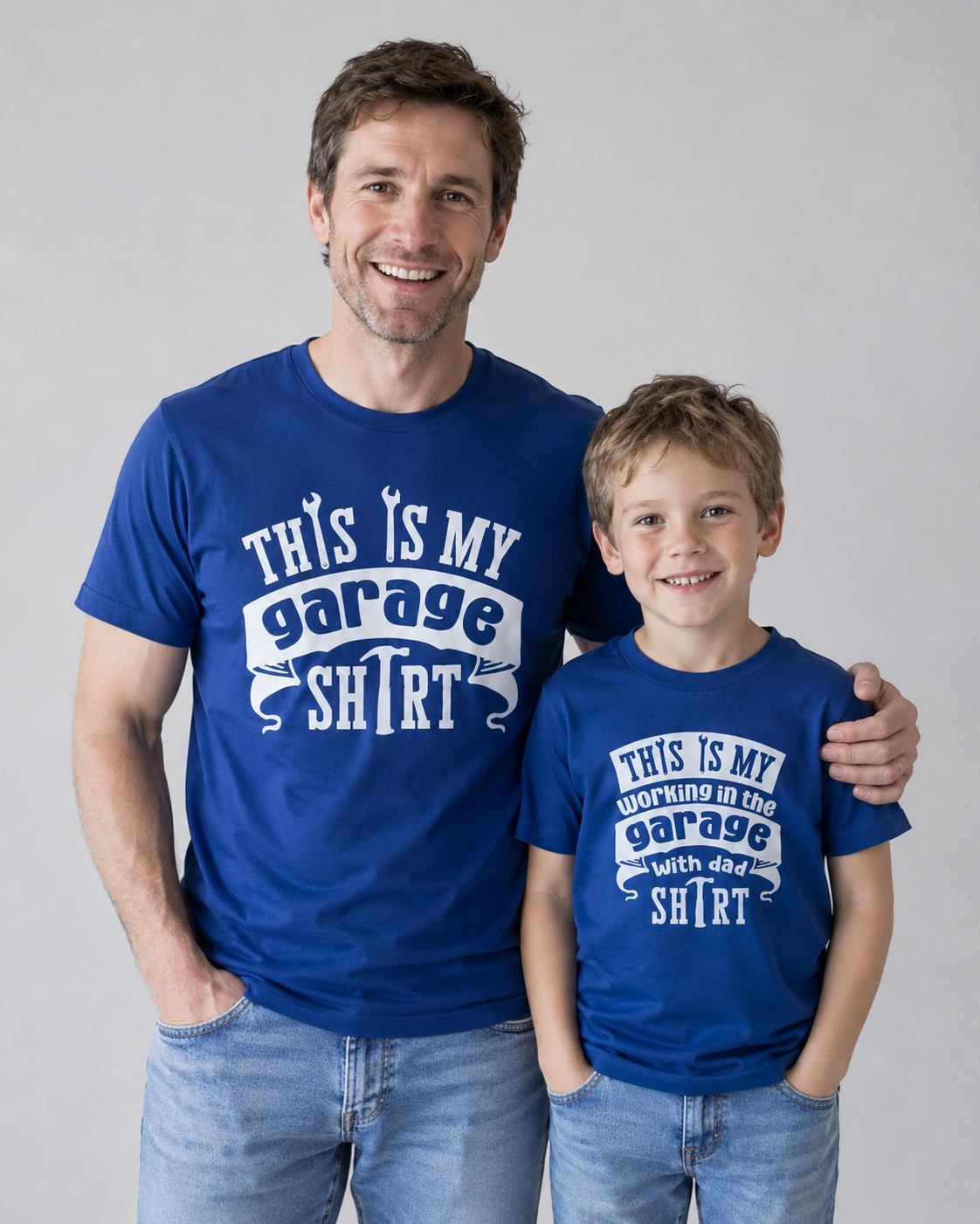 Dad is wearing a royal blue shirt with a text" This is My Garage shirt" and son wears same coloured shirt with the text " This is my Working in the Garage with dad shirt"