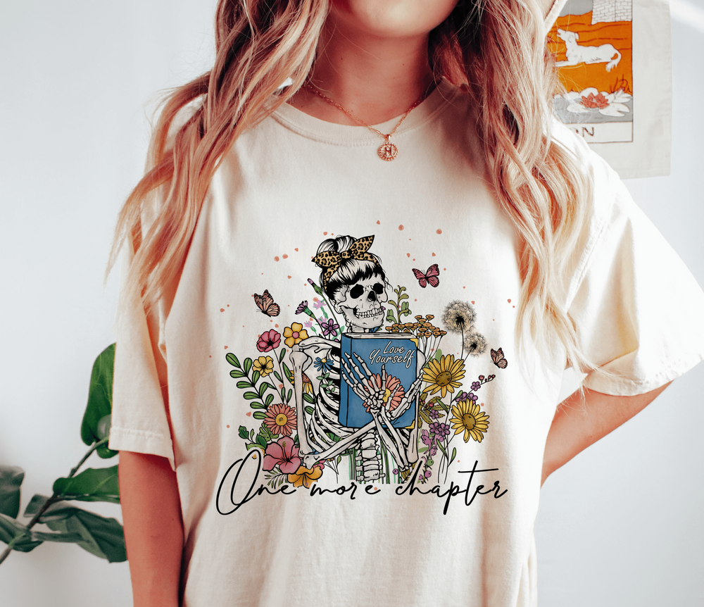 One More Chapter skeleton and wild flowers on Comfort Colors Ivory