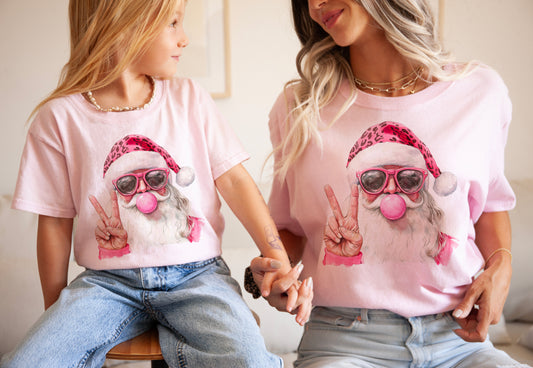 Two people wearing pink t-shirts with a cartoon Santa Claus design.
